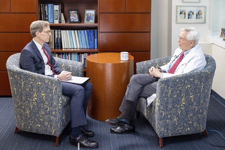Robert Vonderheide, MD, DPhil, director of the Abramson Cancer Center, and John Glick, MD, professor emeritus, sit facing each other in armchairs in Glick's office in March 2021.